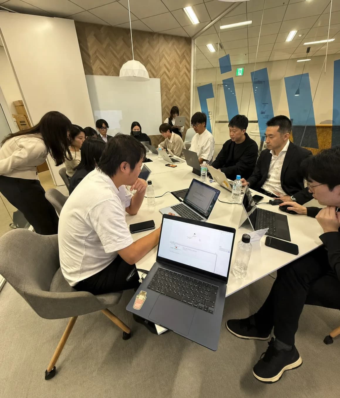 複数の受講者がノートパソコンで実装に取り組む研修風景