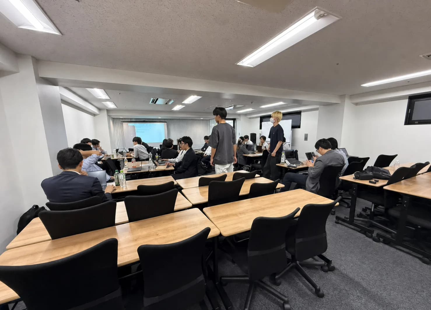 会場で多数の受講者がノートパソコンを使って学ぶ研修風景