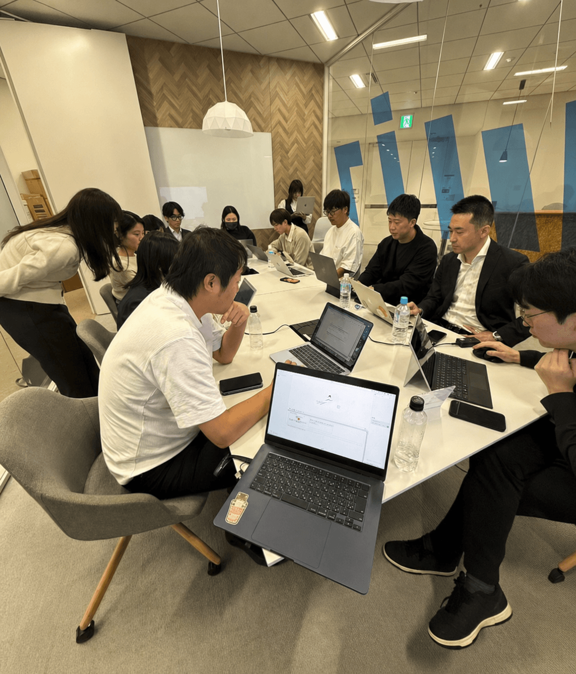 複数の受講者がノートパソコンで実装に取り組む研修風景