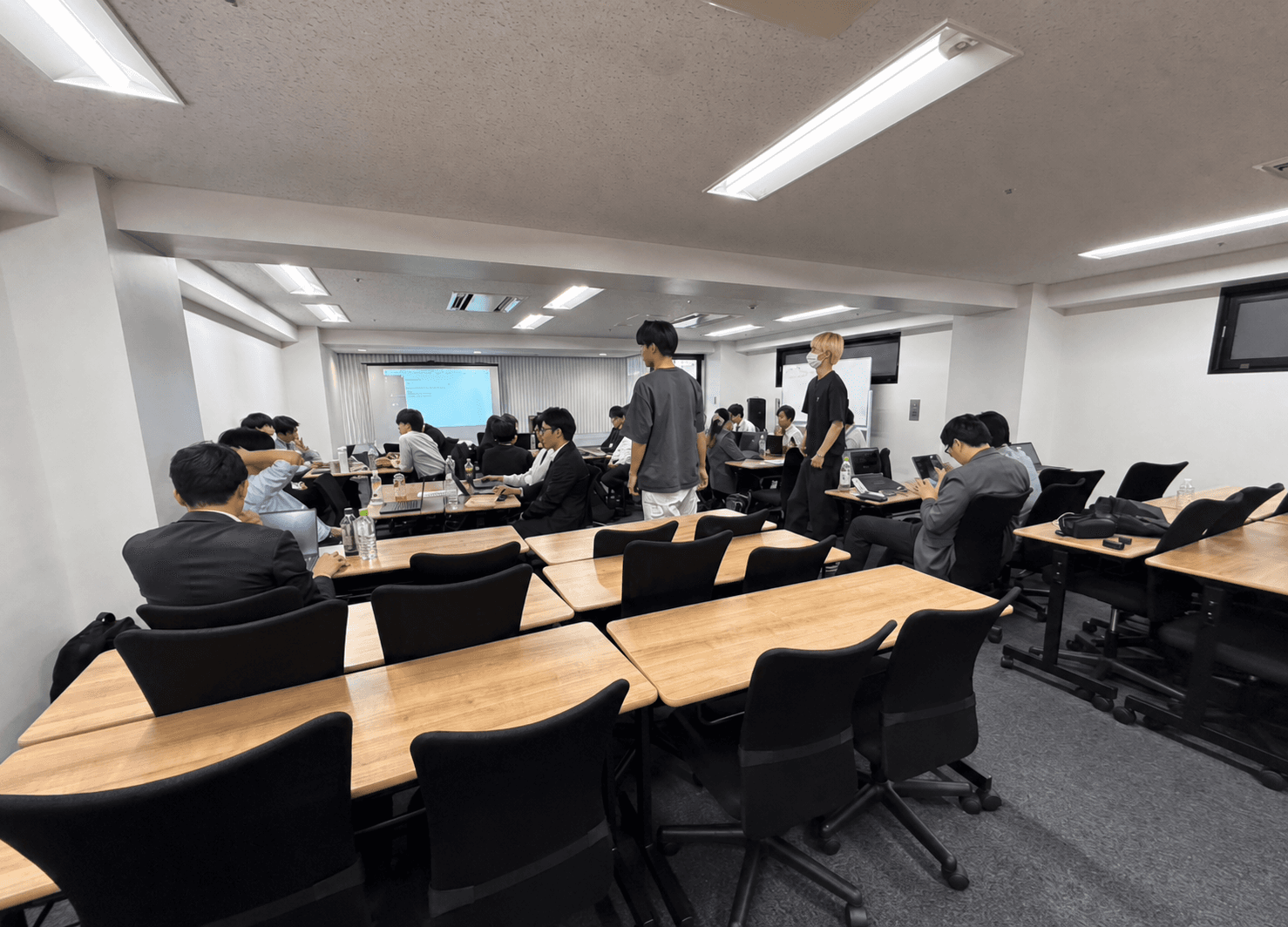 会場で多数の受講者がノートパソコンを使って学ぶ研修風景